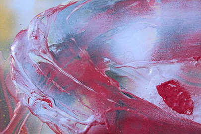 smatters of spray paint blue froth drift and are pulled across thick red paint